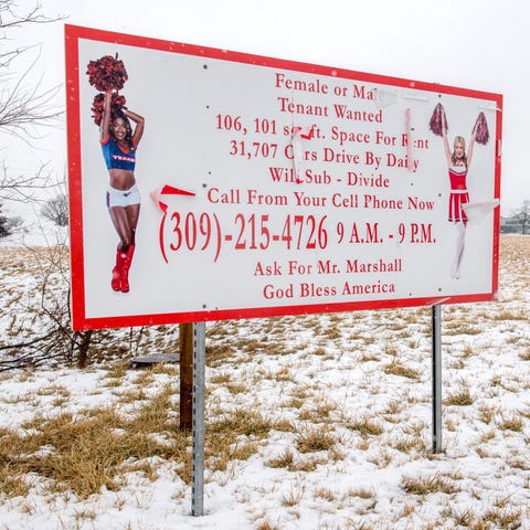 A large sign featuring a pair of cheerleaders adve