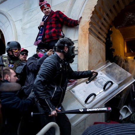 FBI have identified Edward Lang as the man with the shield and baseball bat in this photo from Jan. 6, in which a pro-Trump mob clashes with police and security forces as people try to storm the US Capitol.