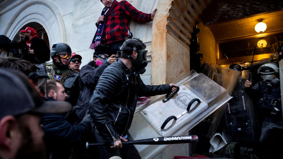 FBI have identified Edward Lang as the man with the shield and baseball bat in this photo from Jan. 6, in which a pro-Trump mob clashes with police and security forces as people try to storm the US Capitol.