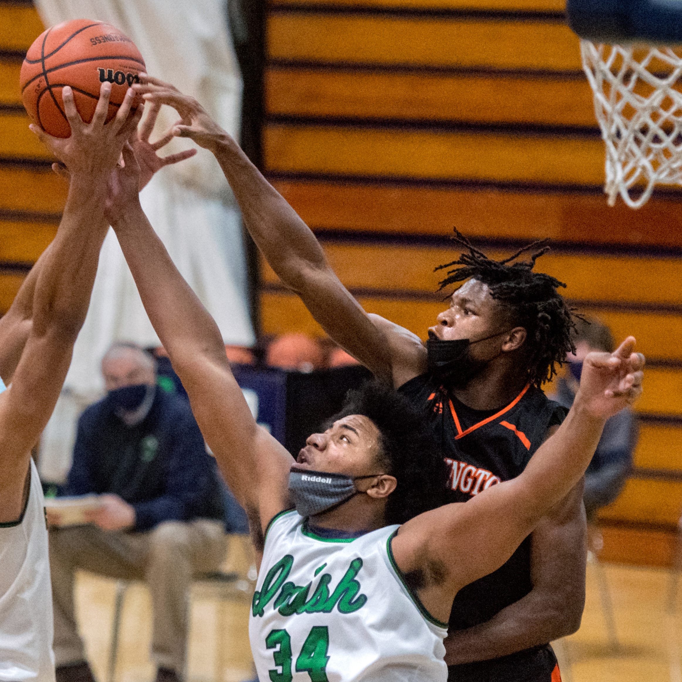 Peoria Notre Dame’s Noah Reynolds (4) and teammate Lathan Sommerville (34) battle for a rebound with Washington’s Drew Lewis in the first half Tuesday, Feb. 9, 2021 at PND High School.