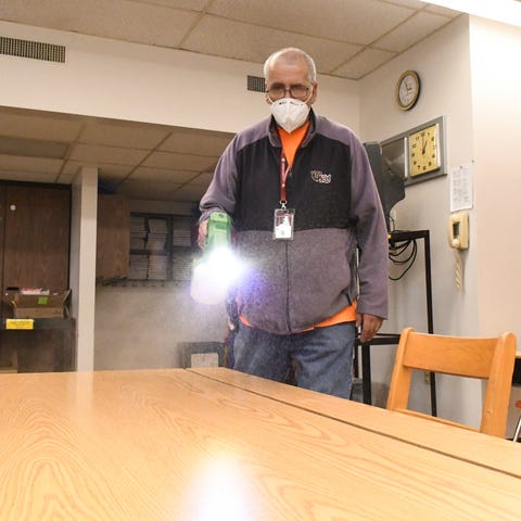 Custodian Rick Wilson cleans a desk using an elect