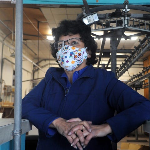 Theresa Sanchez stands at the counter of her busin