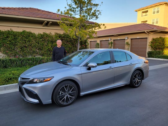 Eric Young stands by the 2021 Toyota Camry he purchased on Feb. 6, 2021.