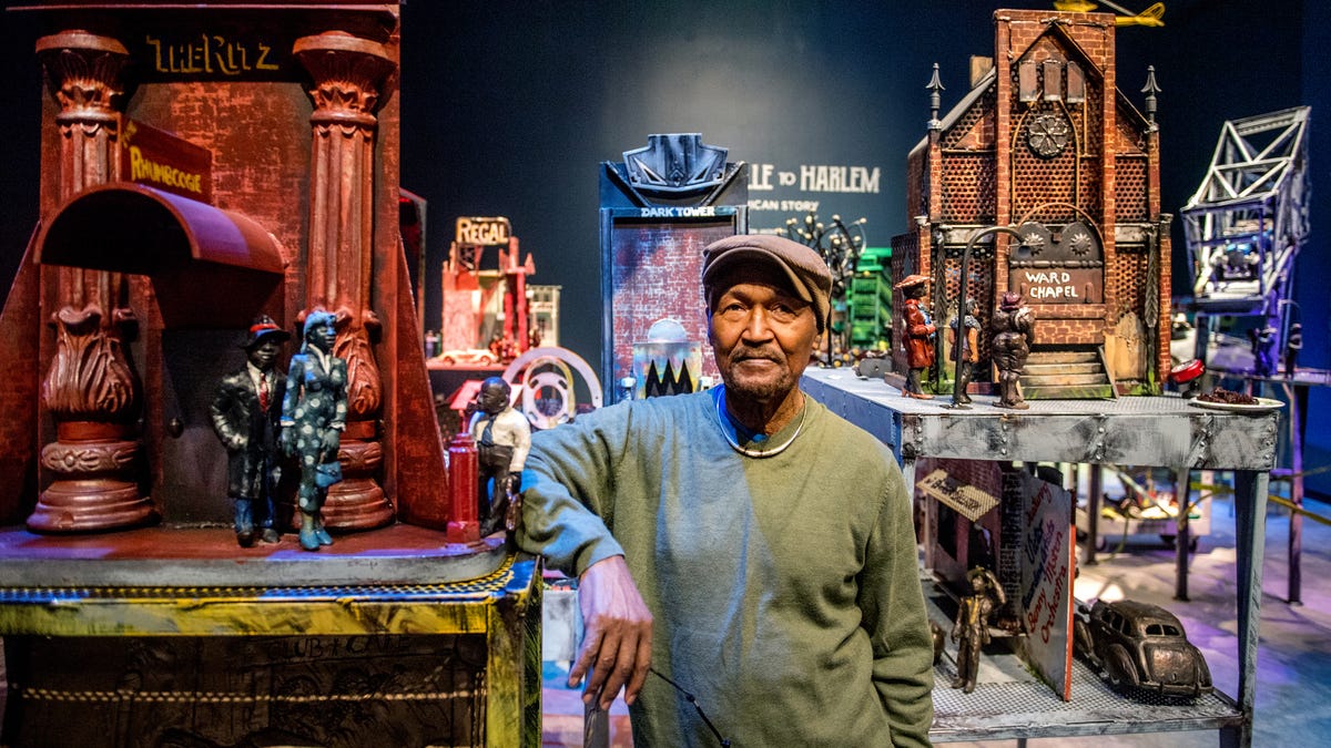 Artist Preston Jackson stands with his creations in the “Bronzeville to Harlem: An American Story” exhibit at the Peoria Riverfront Museum. Jackson has donated the collection, made over a 25-year span, for permanent display at the museum.