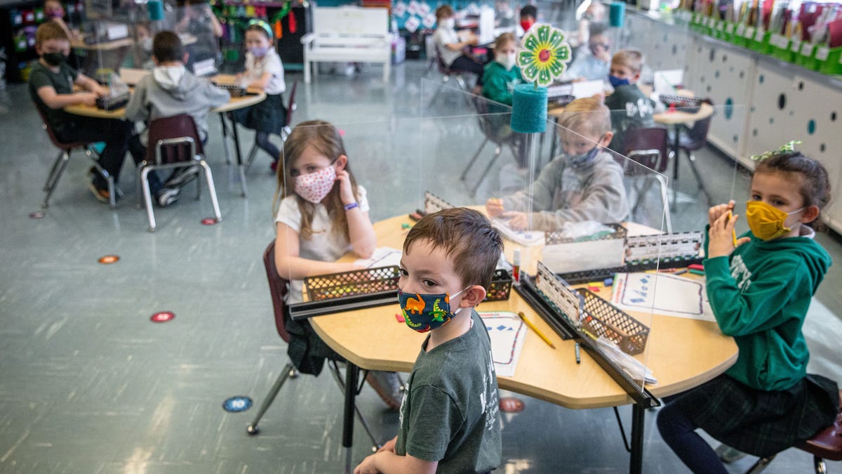 Christ The King kindergartner William Butcher, center, watches kindergartner teacher Jill Johannes go over a lesson using a projector at Christ The King School in Springfield, Ill., Friday, March 5, 2021. Christ the King School has had in-person learning during the COVID-19 pandemic using safety measures such as plexiglass separating students at their desks. [Justin L. Fowler/The State Journal-Register] 