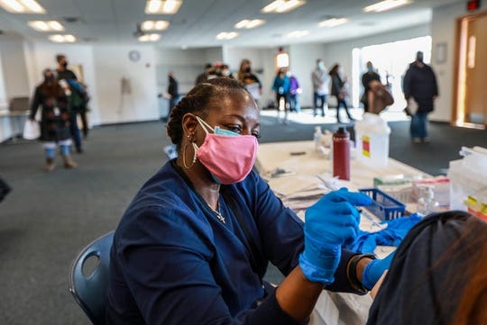 Registered Nurse Benita Rogers, 52, of Redford, Mich., administers the Pfizer COVID-19 vaccine at the Wayne County Community College District Downriver Campus in Taylor, Mich. on Feb. 6, 2021.