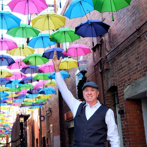 John reaches to grab one of the floating umbrellas