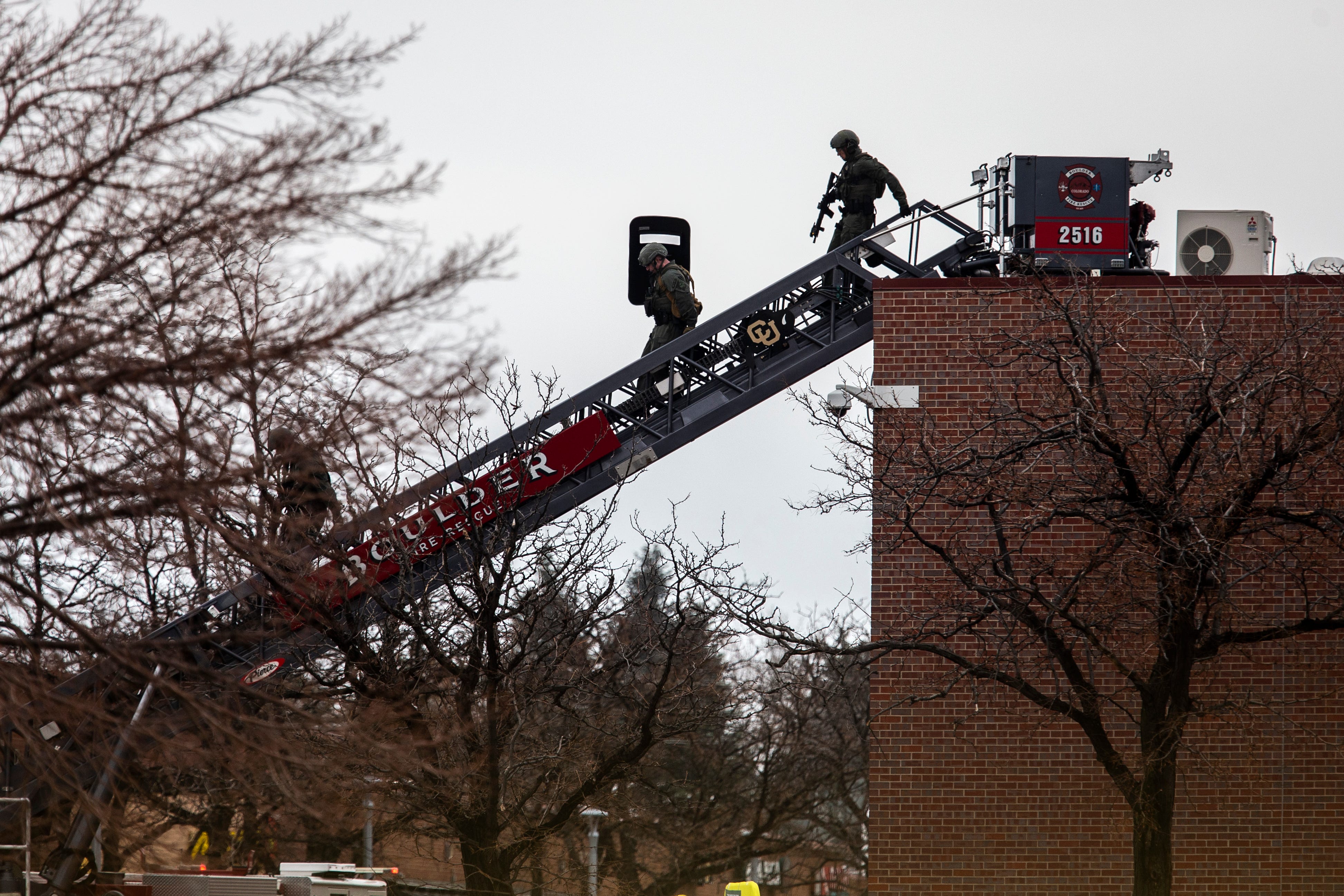 SWAT teams descend from the roof on a fire ladder after a gunman opened fire at a King Sooper's grocery store on March 22, 2021 in Boulder, Colo. Ten people, including a police officer, were killed in the attack.