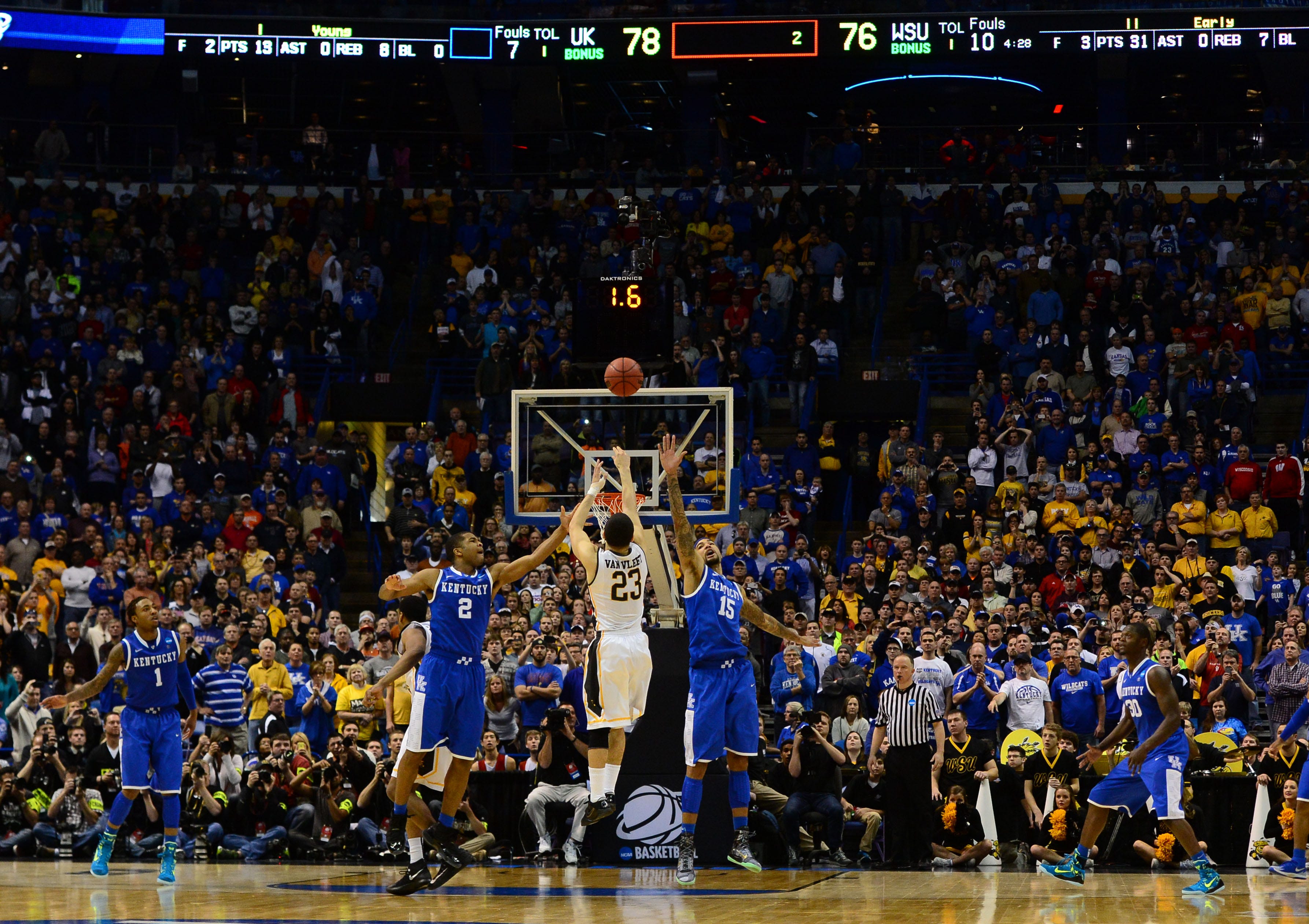 Wichita State guard Fred VanVleet takes a 3-point shot while defended by Kentucky forward Willie Cauley-Stein (15) and Aaron Harrison (2) at the 2014 NCAA Tournament.
