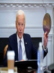 President Joe Biden holds up a silicon wafer as he participates virtually in the CEO Summit on Semiconductor and Supply Chain Resilience in the Roosevelt Room of the White House, Monday, April 12, 2021, in Washington.