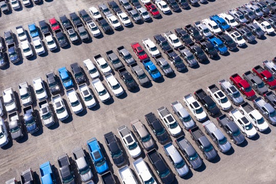 Hundreds of Ford trucks fill a parking lot off I-96 in Detroit, April 25, 2021. A global semiconductor shortage has forced car manufacturers to stockpile unfinished vehicles.