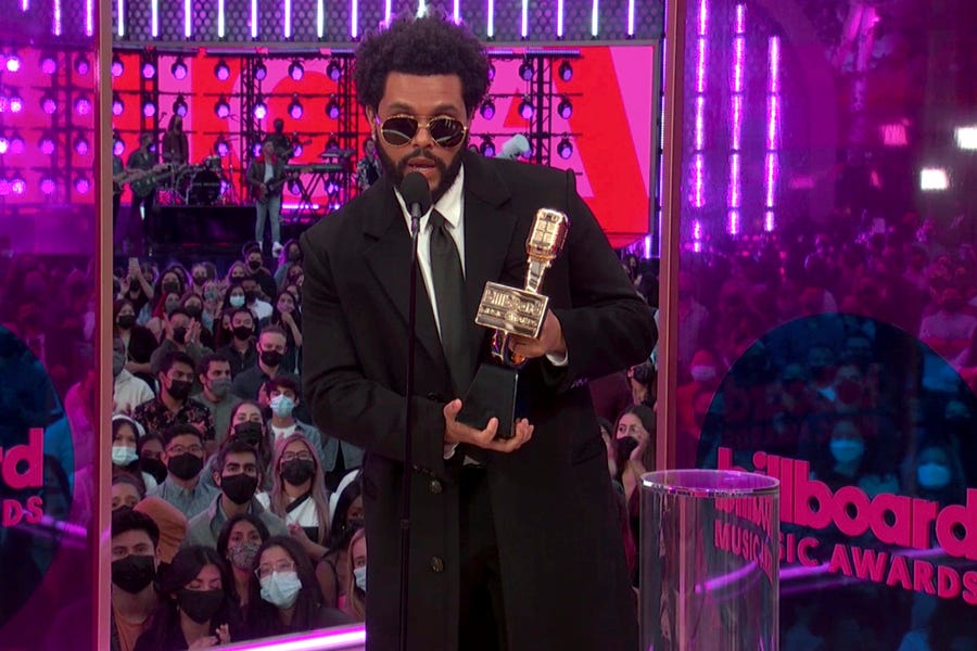 The Weeknd accepts the top artist award.