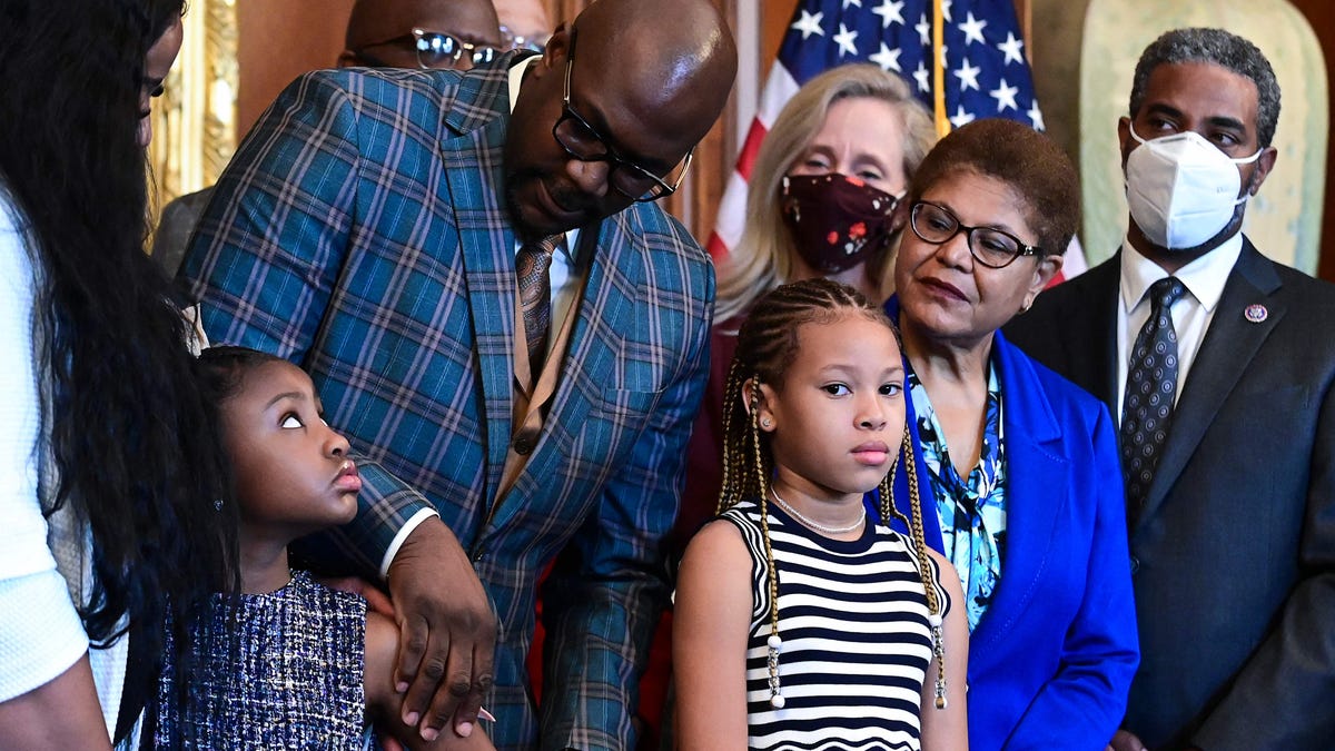 Philonise Floyd, George Floyd's brother, looks down at Gianna Floyd, George Floyd's daughter, while standing with members of the Floyd family prior to a meeting to mark the anniversary of the death of George Floyd with House Speaker Nancy Pelosi, D-Calif.