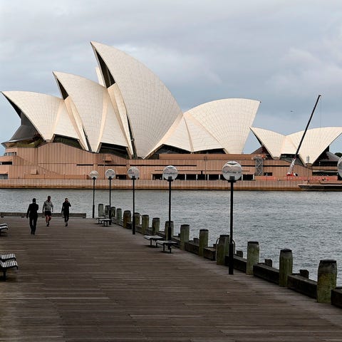 People walk before the Opera House, usually packed