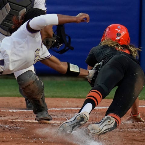 Oklahoma State's Scotland David, right, is tagged 