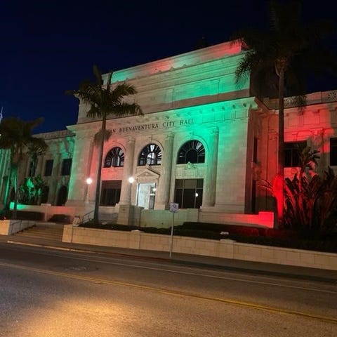 Ventura City Hall is illuminated at night with rai