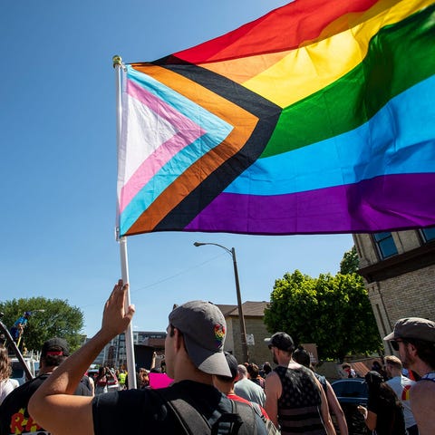 A participant holds a PRIDE flag at the march for 