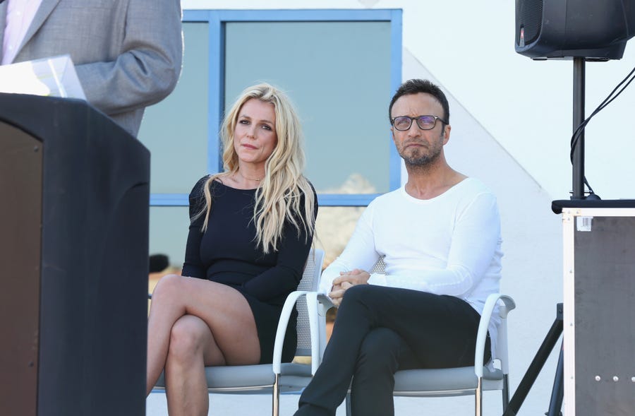 Britney Spears (L) and talent manager Larry Rudolph listen to Clark County Commissioner Steve Sisolak's speech during the grand opening of the Nevada Childhood Cancer Foundation Britney Spears Campus on November 4, 2017 in Las Vegas, Nevada.