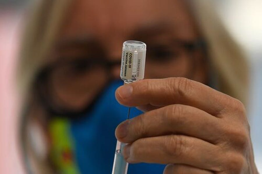 A health worker holds a syringe with a vial of the J&J/Janssen Covid-19 vaccine at a vaccination centre at the Wizink Center in Madrid on May 21, 2021.