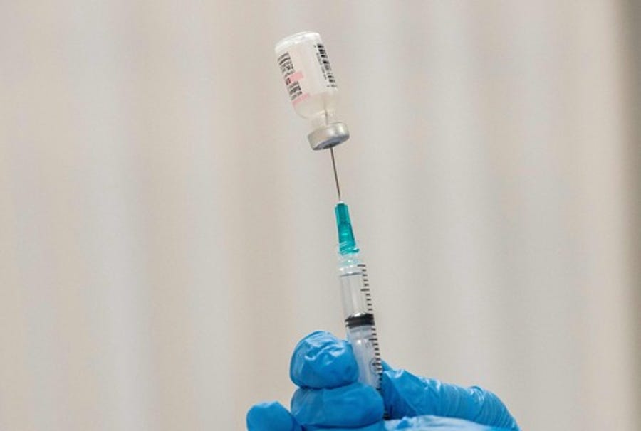 In this file photo taken on April 22, 2021, pharmacist Kathie McDonough reconstitutes the Pfizer-BioNTech Covid-19 vaccine as she fills syringes with the vaccine for the incoming public at the UMass Memorial Health Care Covid-19 Vaccination Center in  Worcester, Massachusetts.