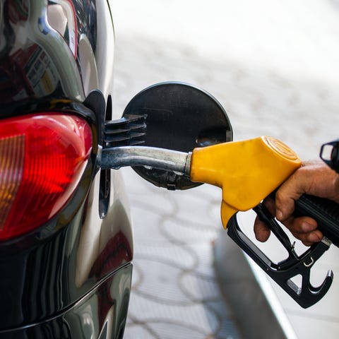 Pumping gas at gas pump. Closeup of man pumping ga