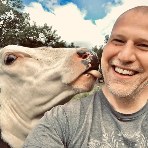 Michael Shank and rescue cow at his animal sanctua