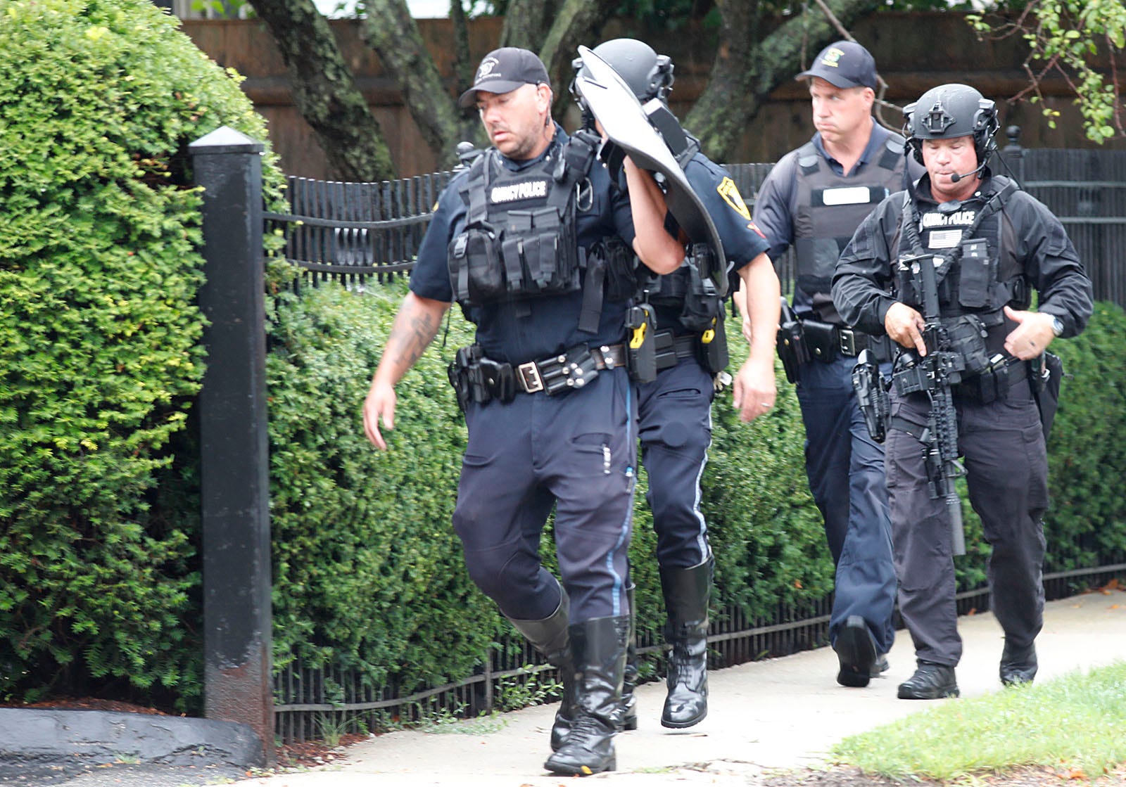 Members of the Quincy police tactical team prepare to enter a building on the 600 block of Quincy Shore Drive on Thursday, Aug. 5, 2021.