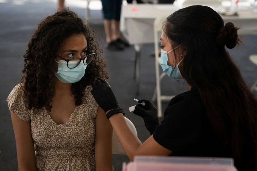 Nurse Noleen Nobleza gives Priscilla Farag, 17, a shot of the Pfizer COVID-19 vaccine at a clinic set up in the parking lot of CalOptima on Aug. 28 in Orange, Calif.