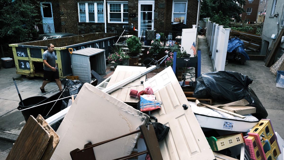 People clean up their flooded homes in a Queens neighborhood that saw massive flooding and numerous deaths following a night of heavy wind and rain from the remnants of Hurricane Ida on September 03, 2021 in New York City.