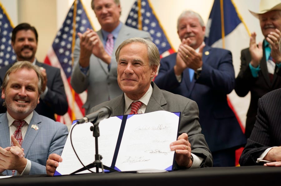 Texas Gov Greg Abbott shows off Senate Bill 1, also known as the election integrity bill, after he signed it into law in Tyler, Texas, Tuesday, Sept. 7, 2021. The sweeping bill signed Tuesday by the two-term Republican governor further tightens Texas' strict voting laws.