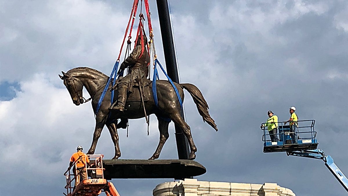 The statue of Confederate General Robert E. Lee is removed from its pedestal on Monument Avenue on September 8, 2021, in Richmond, Virginia. The Commonwealth of Virginia is removing the largest Confederate statue remaining in the U.S. following authorization by all three branches of state government, including a unanimous decision by the Supreme Court of Virginia.