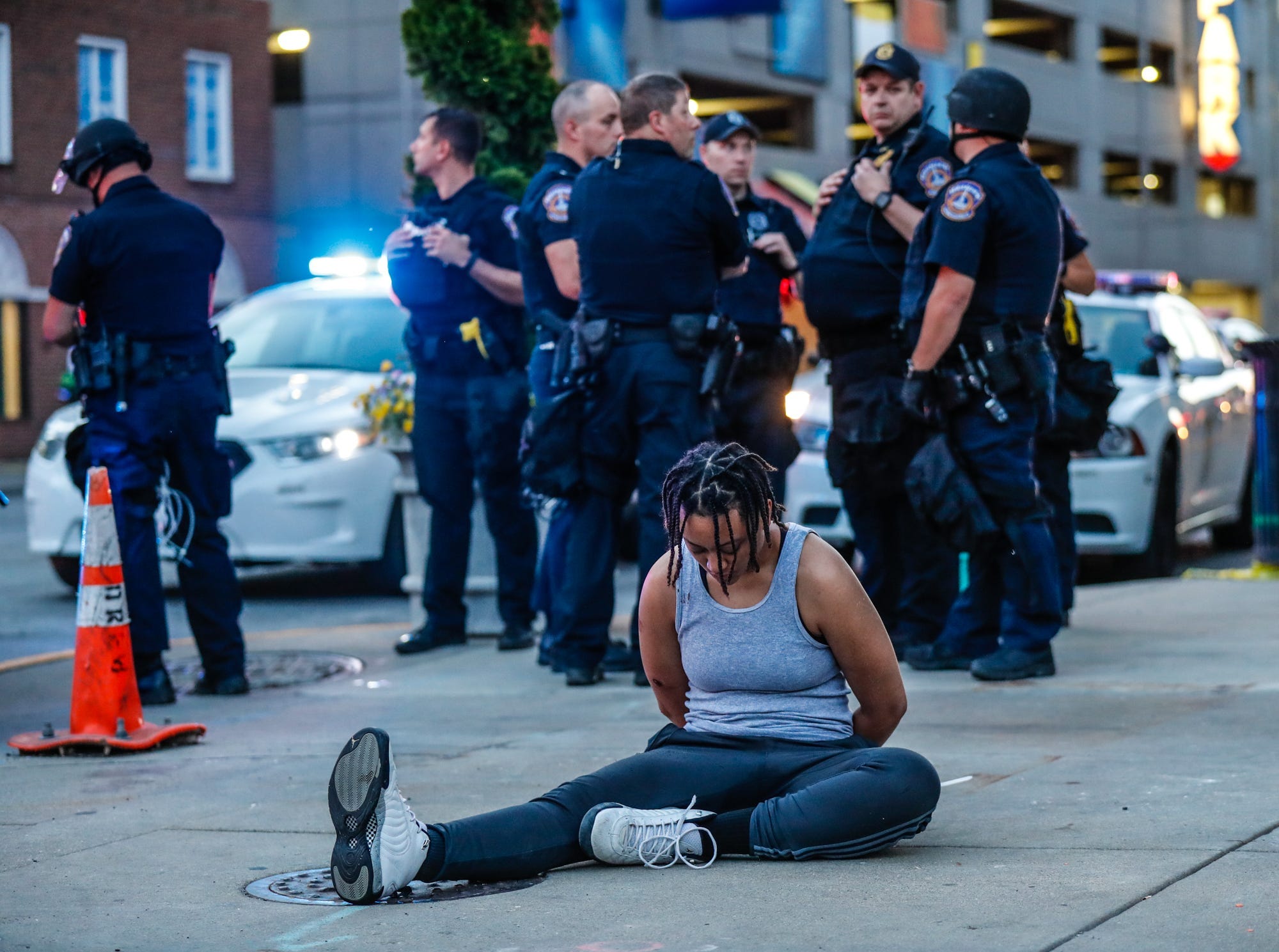 Ivoré Westfield sits at the intersection of Pennsylvania and Washington Streets after she was arrested for a curfew violation by the Indianapolis Metropolitan Police Department. Black Lives Matter protests were broken up in downtown Indianapolis, May 31, 2020.