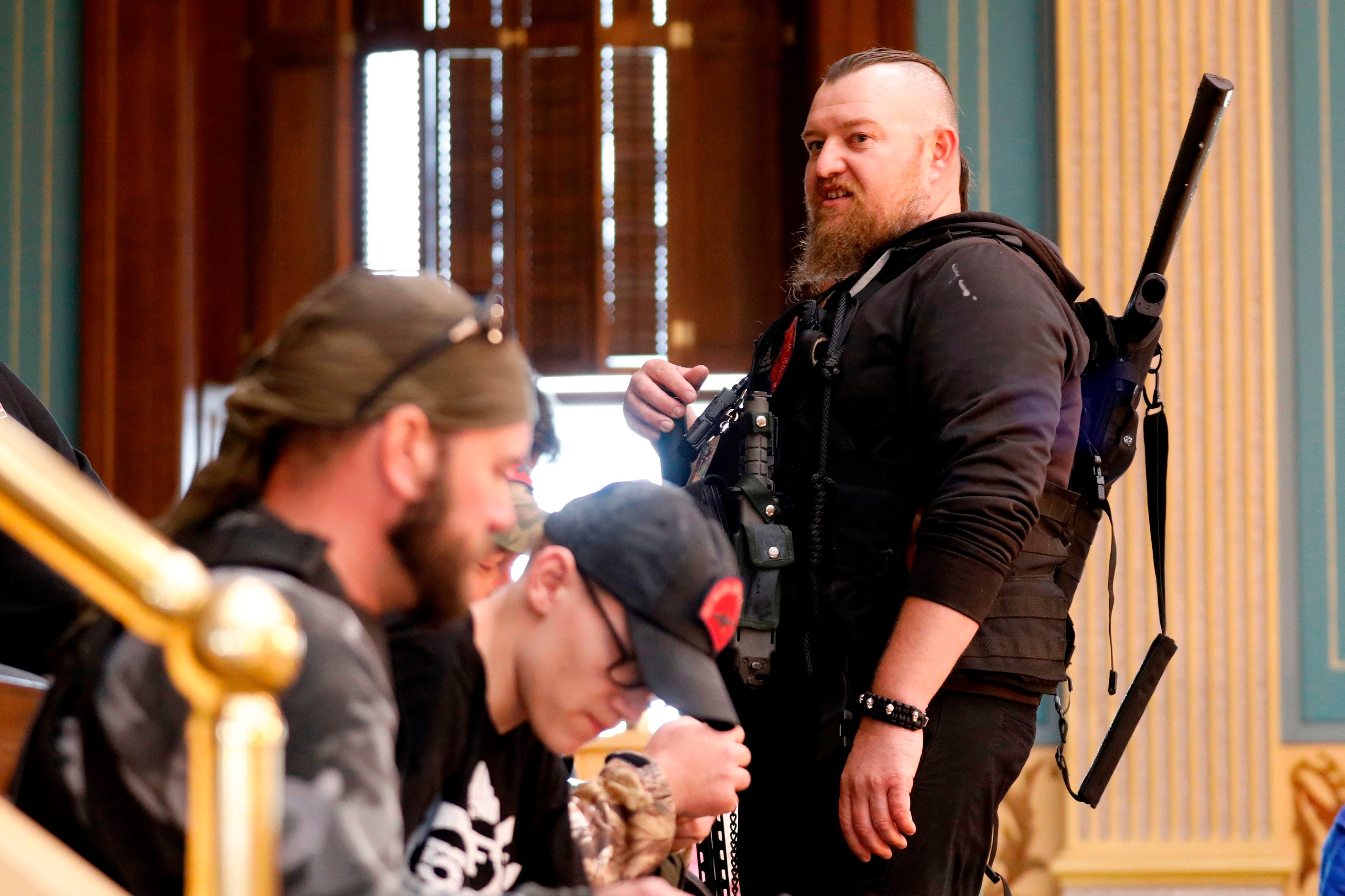 William Null (R) stands in the gallery of the Michigan Senate Chamber during the American Patriot Rally, organized by Michigan United for Liberty, to demand the reopening of businesses on the steps of the Michigan State Capitol in Lansing, Michigan, on April 30, 2020. Others are unidentified. Thirteen men, including members of two right-wing militias, have been arrested for plotting to kidnap Michigan Governor Gretchen Whitmer and "instigate a civil war", Michigan Attorney General Dana Nessel announced on October 8, 2020. The Nulls were charged for their alleged roles in the plot to kidnap Whitmer, according to the FBI. The brothers are charged with providing support for terroristic acts and felony weapons charges.