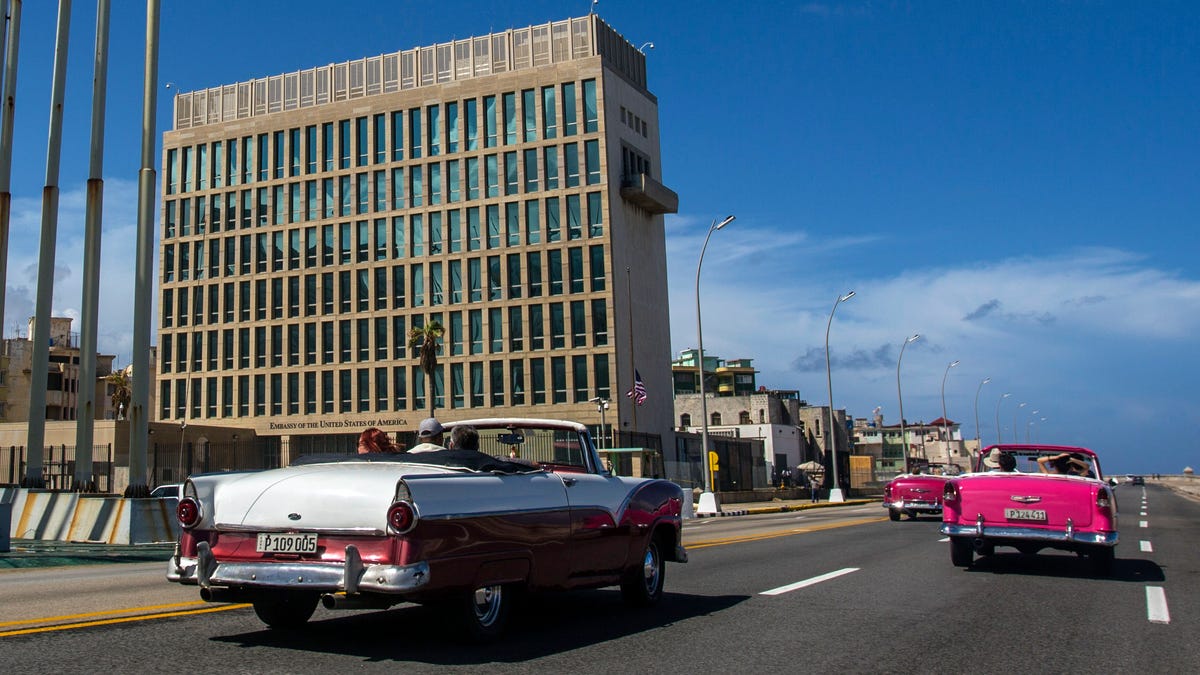 In this Oct. 3, 2017, file photo, tourists ride classic convertible cars on the Malecon beside the United States Embassy in Havana, Cuba. The Biden administration faces increasing pressure to respond to a sharply growing number of reported injuries suffered by diplomats, intelligence officers and military personnel that some suspect are caused by devices that emit waves of energy that disrupt brain function. The problem has been labeled the â€œHavana Syndrome,â€   because the first cases affected personnel in 2016 at the U.S. Embassy in Cuba.