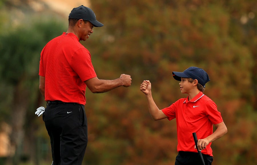 Tiger Woods and son Charlie fist bump on the 18th hole during the final round of the 2020 PNC Championship.