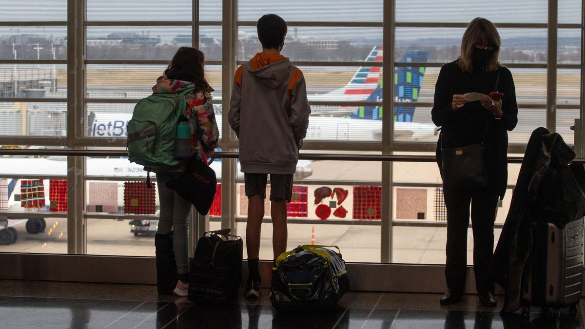 Travelers watch planes on the tarmac at Ronald Reagan International Airport in Washington, DC on Dec. 27, 2021.