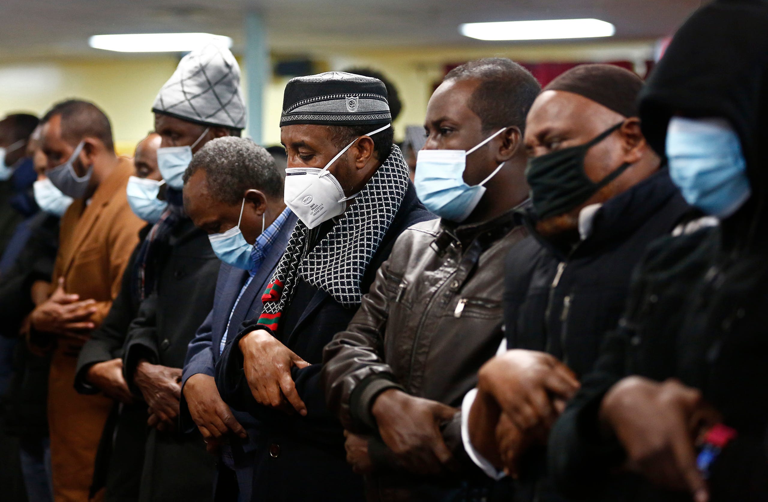 Men pray during a memorial service for slain Imam Mohamed Hassan Adam at IbnuTaymiyah Masjid and Islamic Center on Thursday, December 30, 2021.