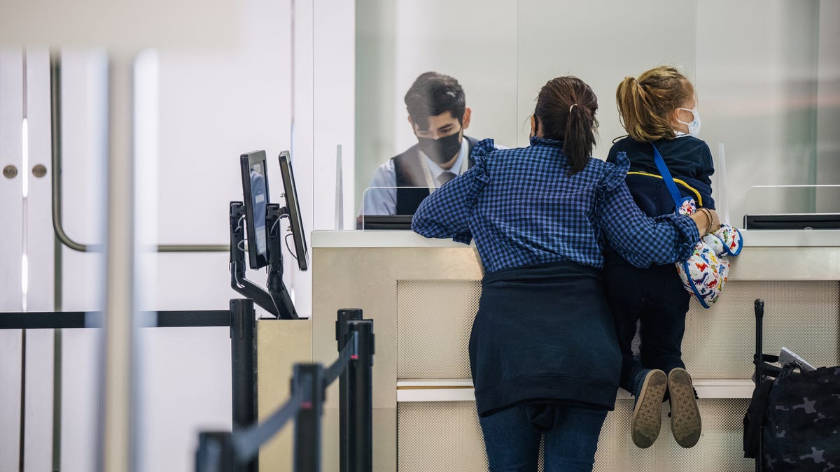 A woman and her child speak with an airline attendant at Houston's George Bush Intercontinental Airport on Jan. 6, 2022 as thousands of U.S. flights were canceled again. (Photo by Brandon Bell/Getty Images)