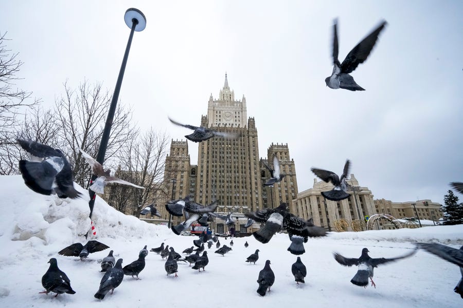 Pigeons take off in front of the Russian Foreign Ministry building in Moscow on Jan. 26, 2022. Russian Foreign Minister Sergey Lavrov said he and other top officials will advise President Vladimir Putin on the next steps after receiving written replies from the United States to the demands. Those answers are expected this week — even though the U.S. and its allies have already made clear they will reject the top Russian demands.