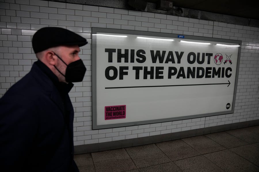 January 27, 2022:  A man wearing a face mask to curb the spread of coronavirus walks past a health campaign poster from the One NGO, in an underpass leading to Westminster underground train station, in London. Most coronavirus restrictions including mandatory face masks were lifted in England on Thursday, after Britain's government said its vaccine booster rollout successfully reduced serious illness and COVID-19 hospitalizations. From Thursday, face coverings are no longer required by   law anywhere in England.