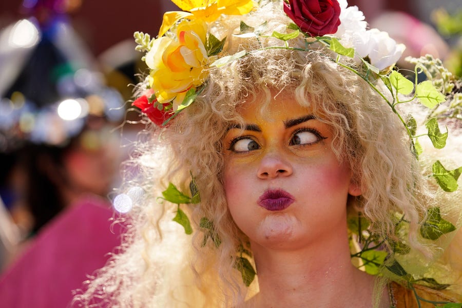 A person makes faces as they march in the Societe de Sainte Anne parade during Mardi Gras on Tuesday, March 1, 2022, in New Orleans. (AP Photo/Gerald Herbert)