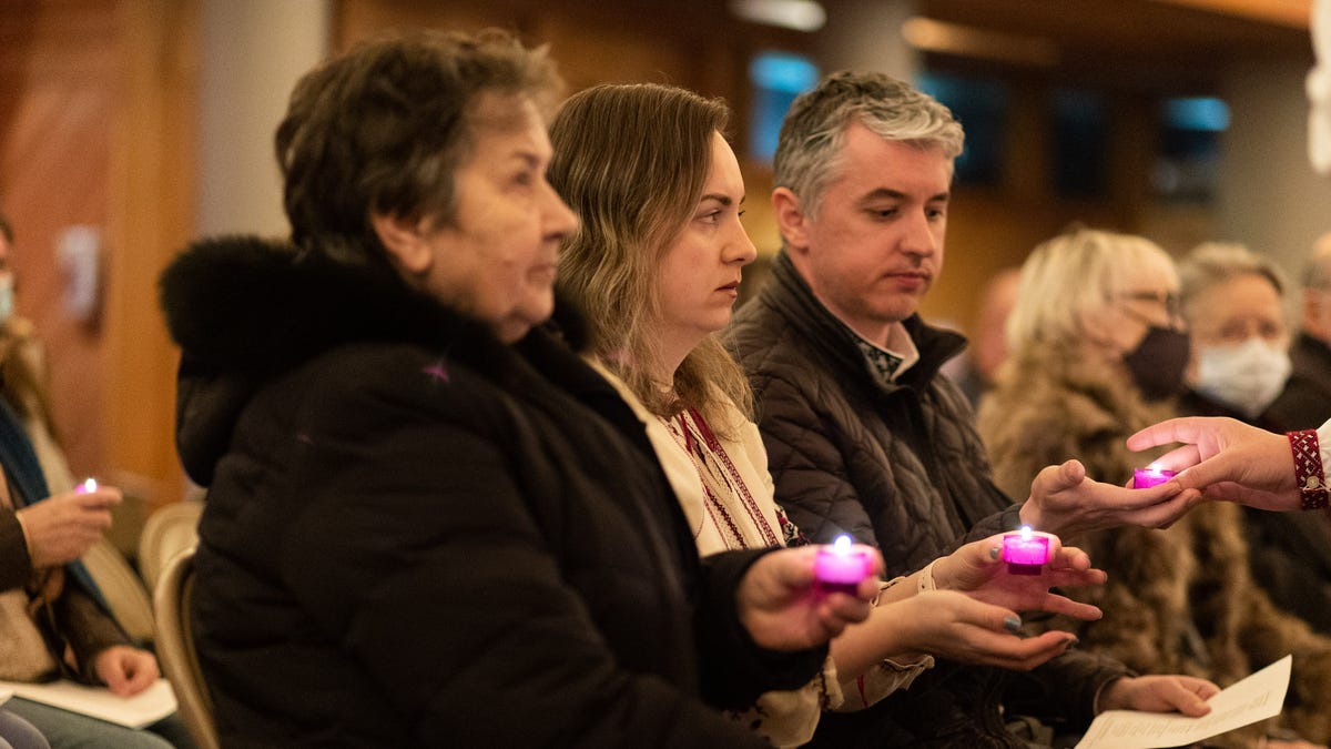 Maria Nemelivsky, center, holds a candle at a prayer vigil for Ukraine at Holy Trinity Ukrainian Catholic Church in Kerhonkson, NY, on Tuesday, March 1, 2022.