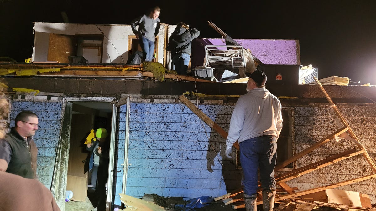 People remove belongings from their home after a tornado in Winterset, Iowa, on March 5.