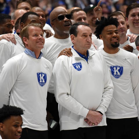 Mike Krzyzewski poses for a picture with former pl