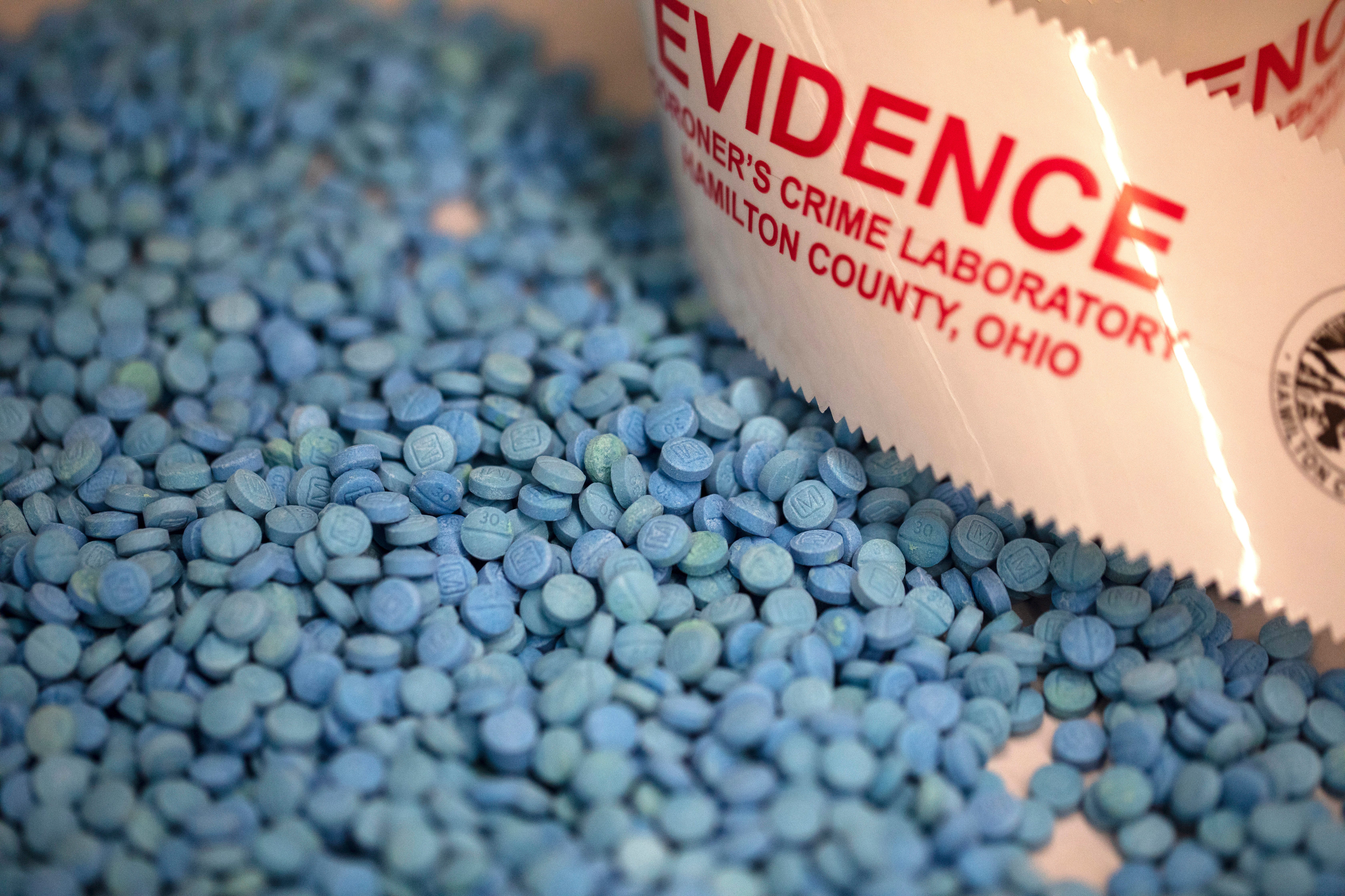 Laura Kimble, senior drug chemist and forensic scientist with the Hamilton County Coroner's Crime Laboratory located in Blue Ash, shows some of the fake oxycodone that was seized in a large drug bust. The fake pills contain fentanyl and acetaminophen.