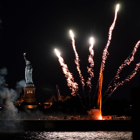 Fireworks launched from a barge explode over New Y