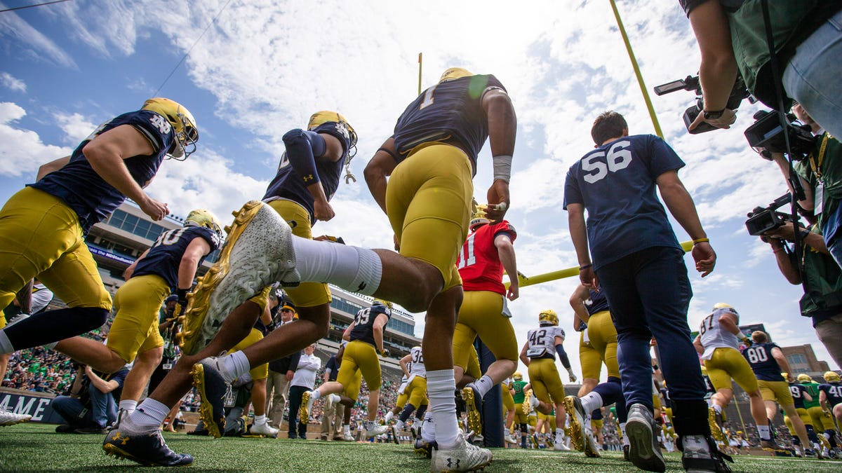 Players run onto the field during the Notre Dame Blue-Gold Spring Football game on Saturday, April 23, 2022, at Notre Dame Stadium in South Bend.