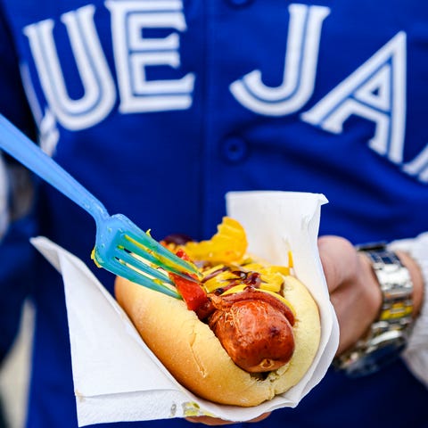 A fan puts condiments on a hot dog before the Blue