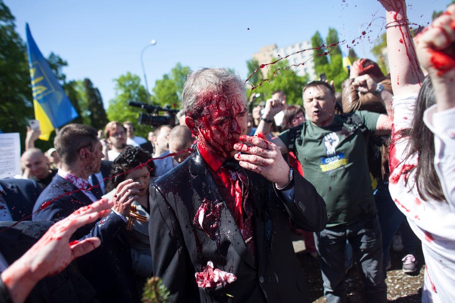 May 9, 2022:  Russian Ambassador to Poland, Ambassador Sergey Andreev is covered with red paint in Warsaw, Poland. Protesters threw red paint on the Russian ambassador as he arrived at a cemetery in Warsaw to pay respects to Red Army soldiers who died during World War II. Ambassador Sergey Andreev arrived at the Soviet soldiers cemetery on Monday to lay flowers where a group of activists opposed to Russia's war in Ukraine were waiting for him.