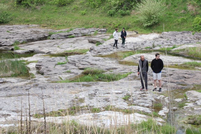 People walk around the Devonian Fossil Gorge in Iowa City, May 18. The site contains bedrock from 375 million years ago.